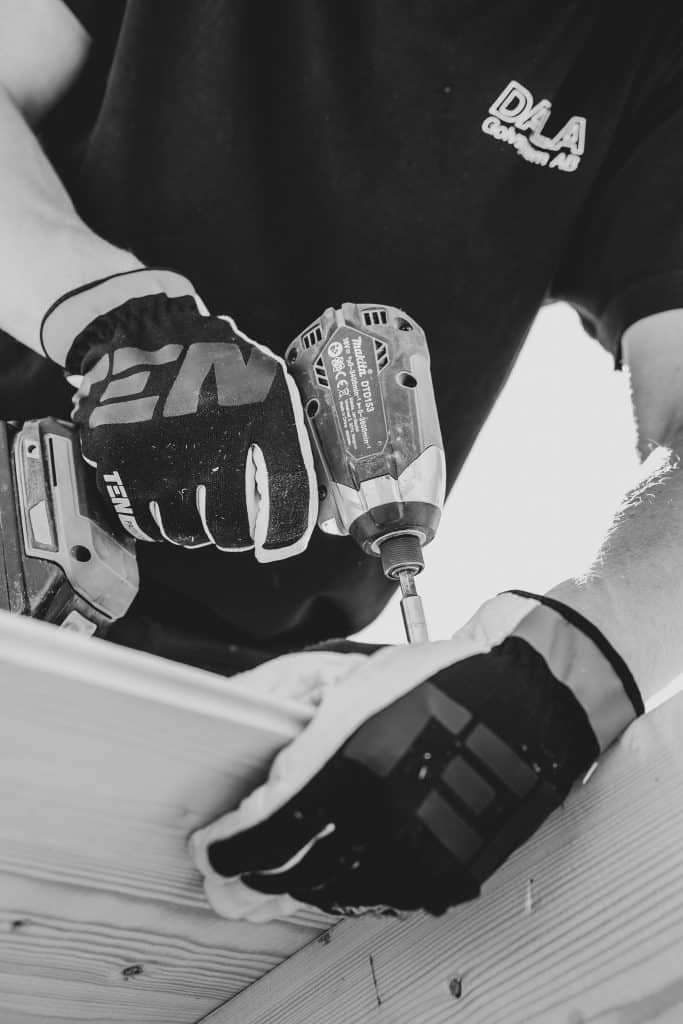 First image highlighting an individual holding a power drill for the 24/7 emergency boarding section in black and white