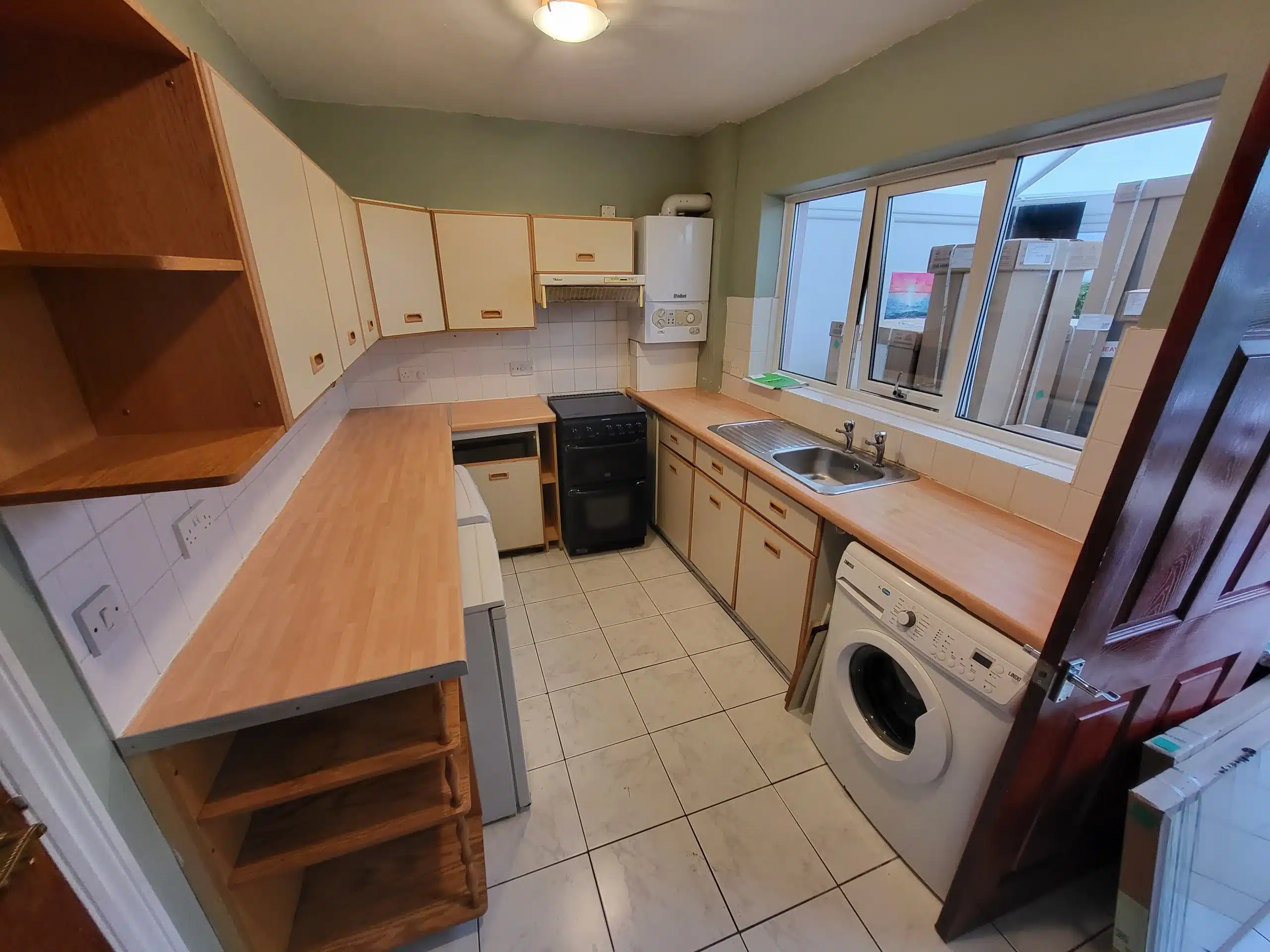Kitchen fitting example showing wooden counters and appliances that were installed