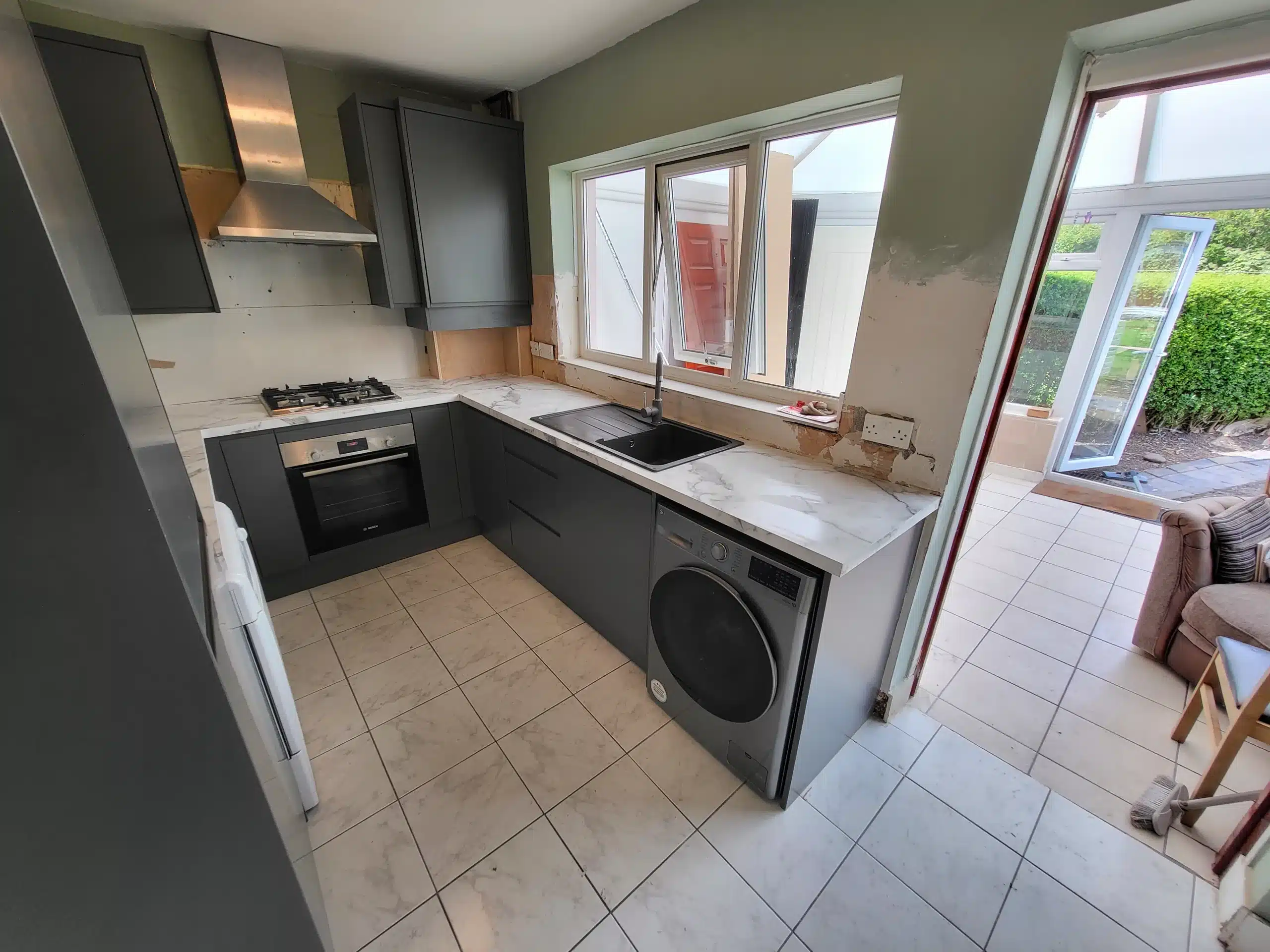 Modern kitchen fitting example first image showing an oven and stove-top from a wide angle